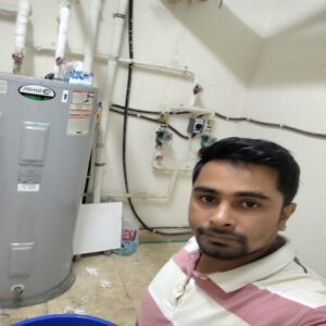 A plumber posing in front of an AO Smith water heater, highlighting his installation and maintenance work